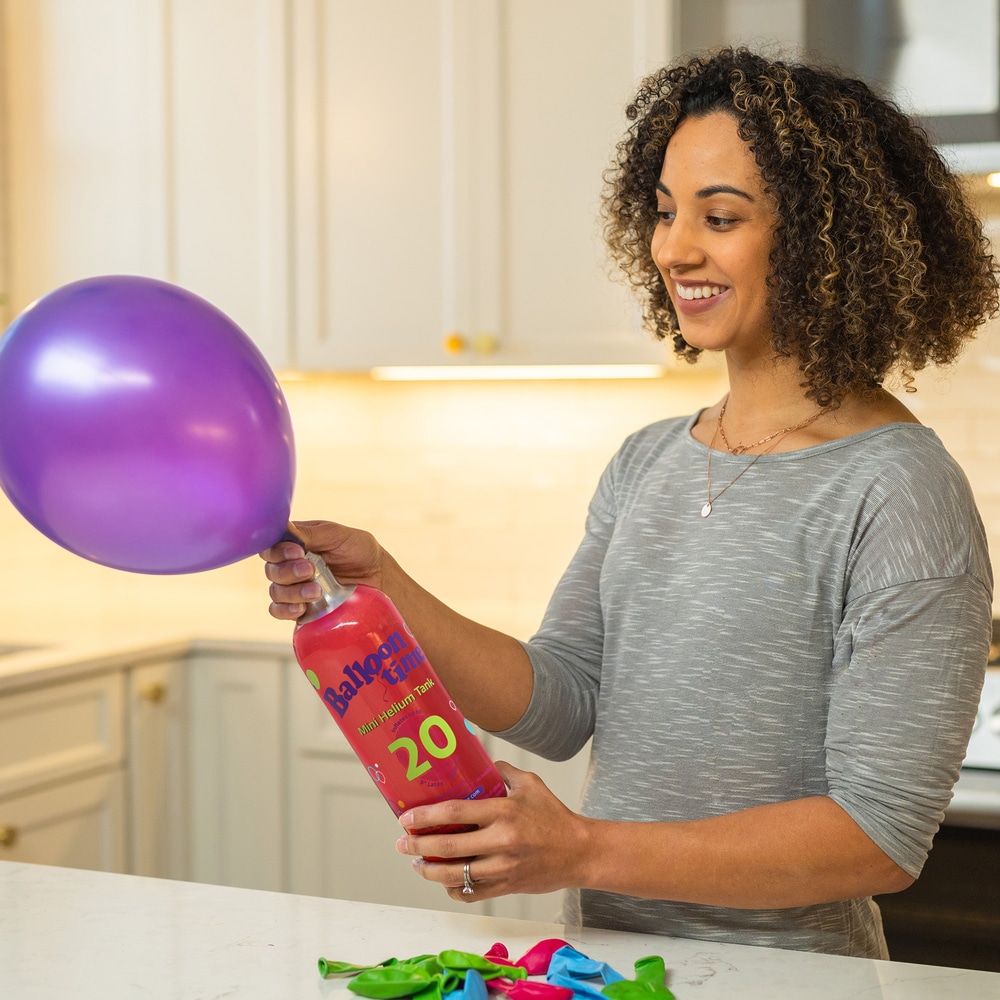 Woman filling balloon with Mini Tank